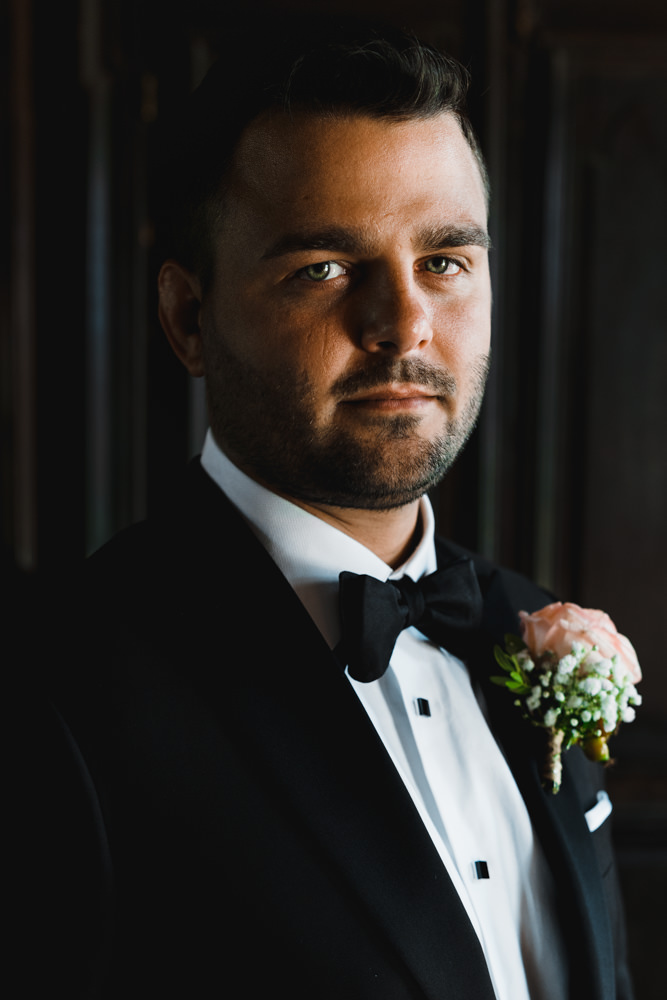Dramatic lighting for a beautiful groom's portrait during a wedding